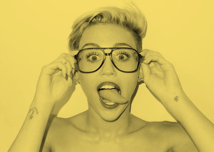 Pop singer Miley Cyrus sticks out her tongue in her signature pose