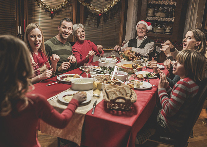 A family gathers around the Christmas table for dinner.